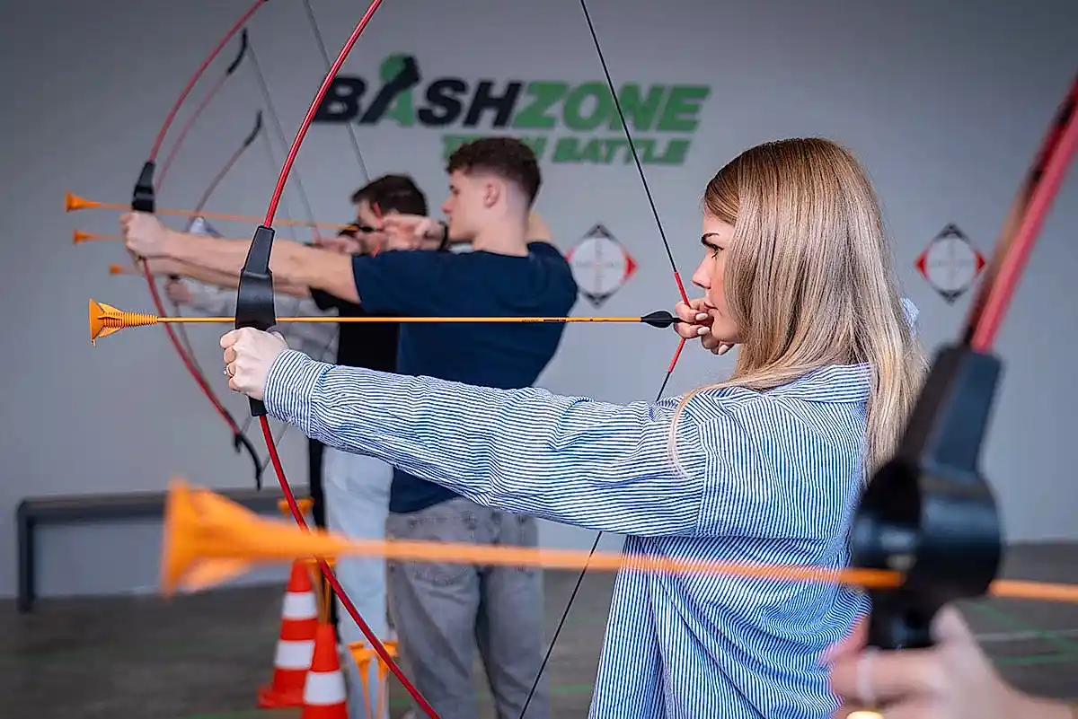 frau zielt mit pfeil und bogen bei bashzone challenge