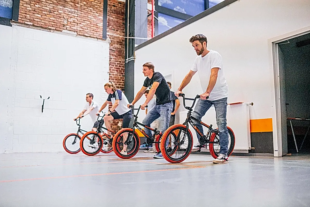 jugendliche meistern gemeinsam einen trickparcours mit bmx bikes bei einem teamevent
