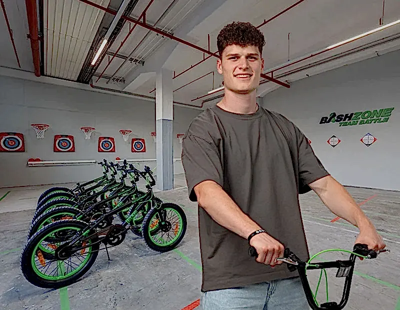teilnehmender fahrt mit bmx raddurch einen trickparcours in der eventhalle der bashzone.