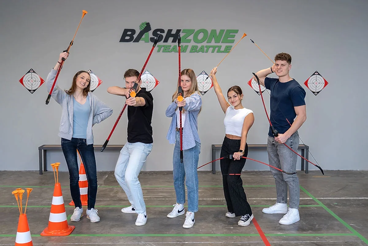 gruppe junger teilnehmenden posiert mit pfeil und bogen