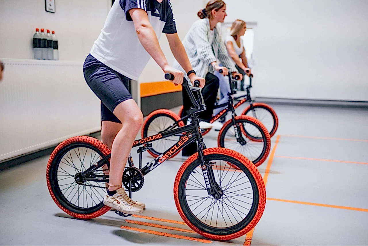 teilnehmende meistern gemeinsam einen trickparcours mit bmx bikes bei einem teamevent